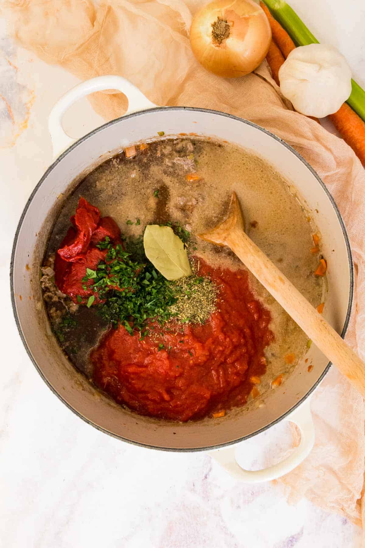 bolognese sauce in a pot with tomatoes, herbs and meat