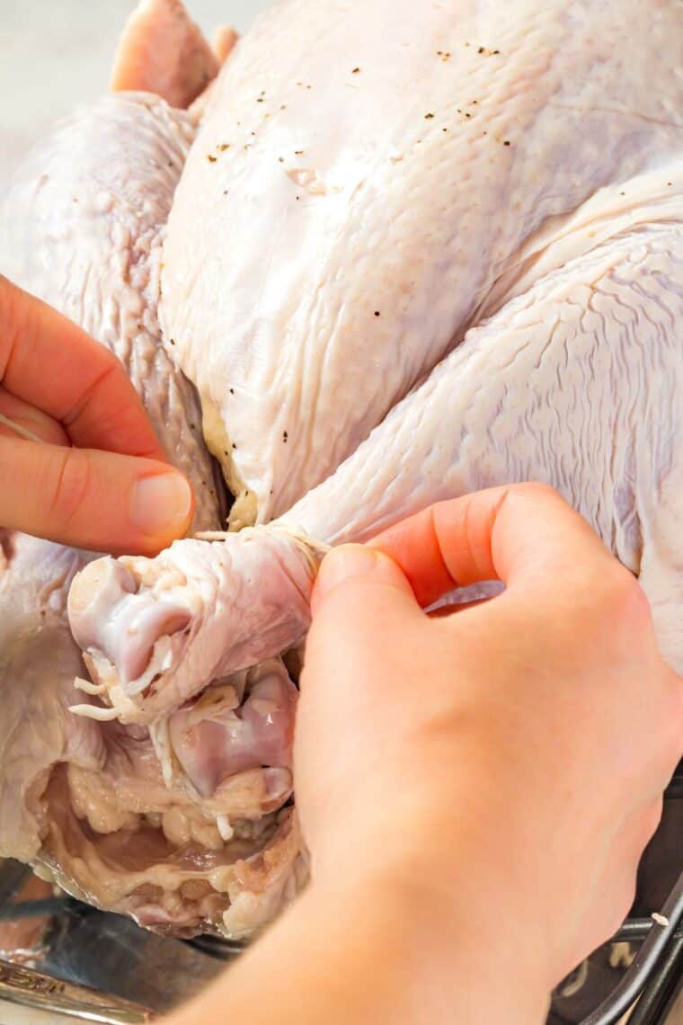 tying the turkey legs together with kitchen twine