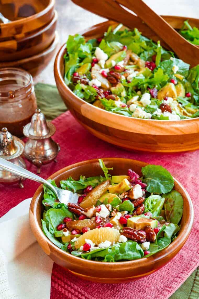 small wooden bowl with a serving of winter salad with oranges and pomegranates