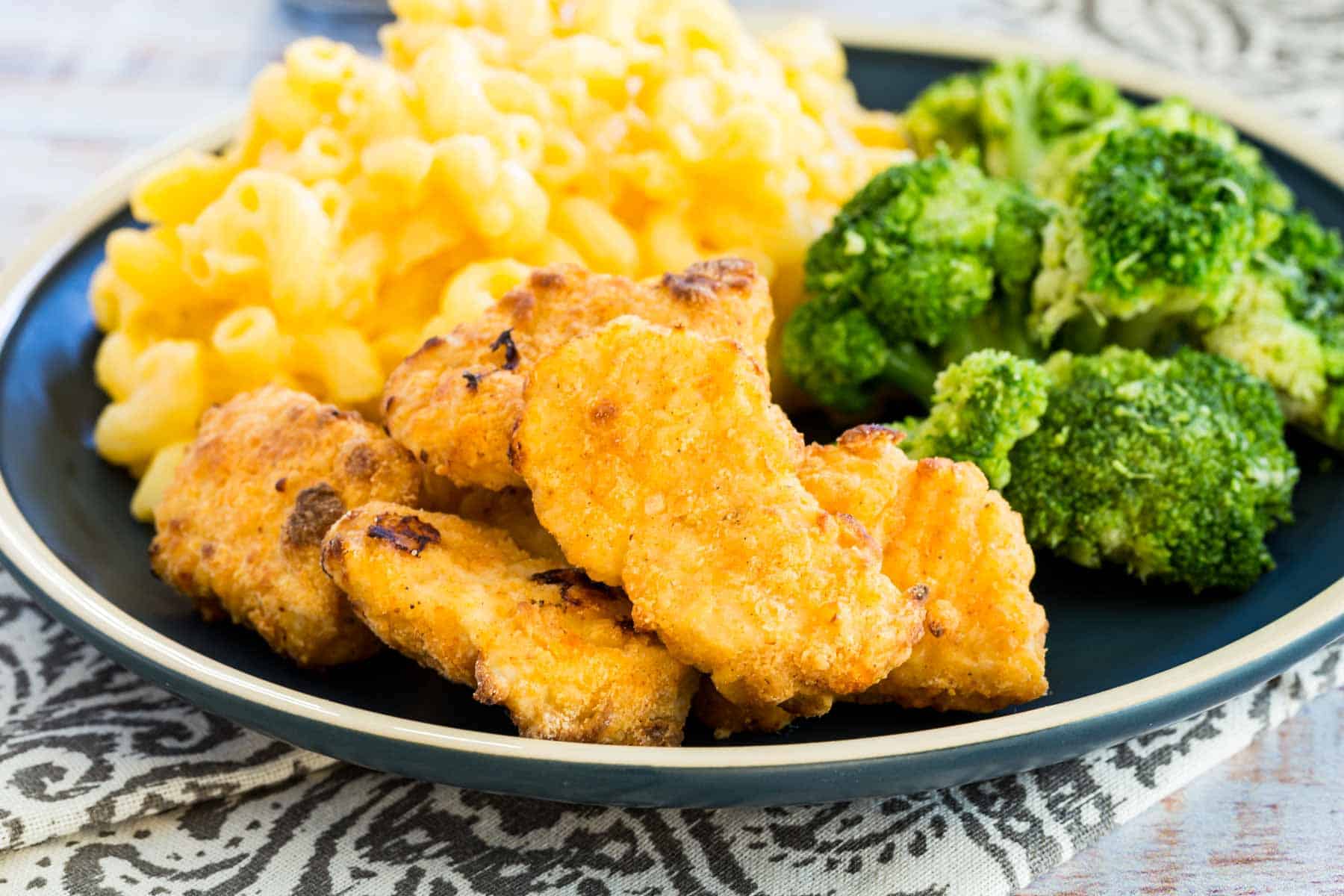 Air fryer chicken nuggets served with mac and cheese and broccoli.