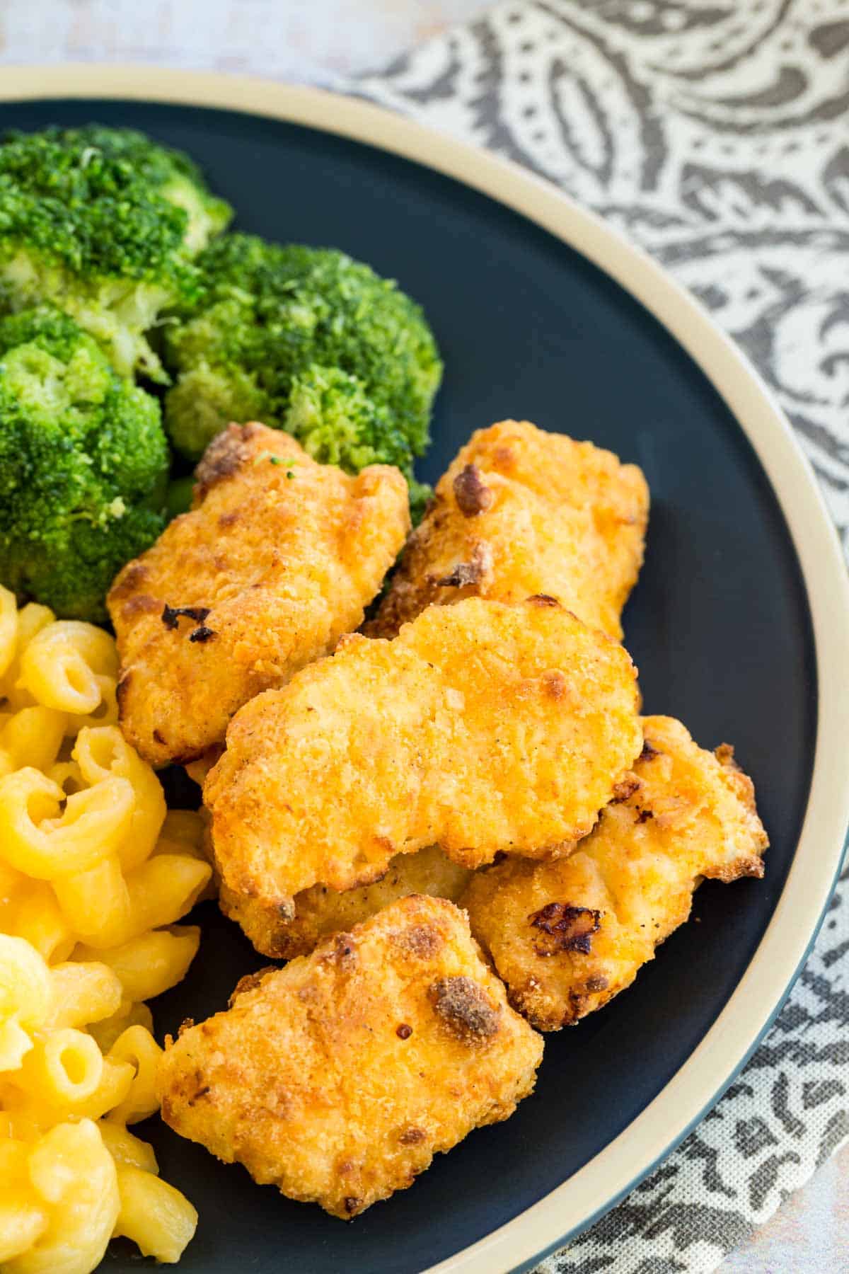 Air fryer chicken nuggets served with mac and cheese and broccoli.
