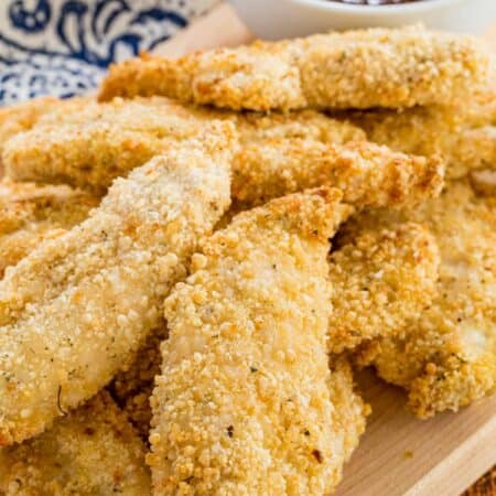 Air fryer chicken tenders served next to a bowl of BBQ sauce for dipping.