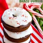 three stacked iced chocolate donuts on a red and white striped plate