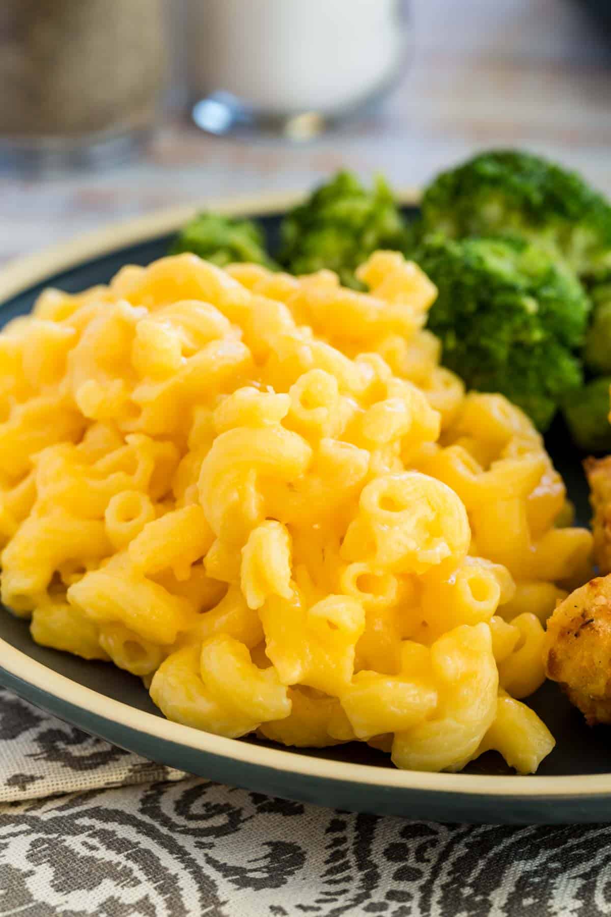Stovetop mac and cheese served on a plater with broccoli and chicken.
