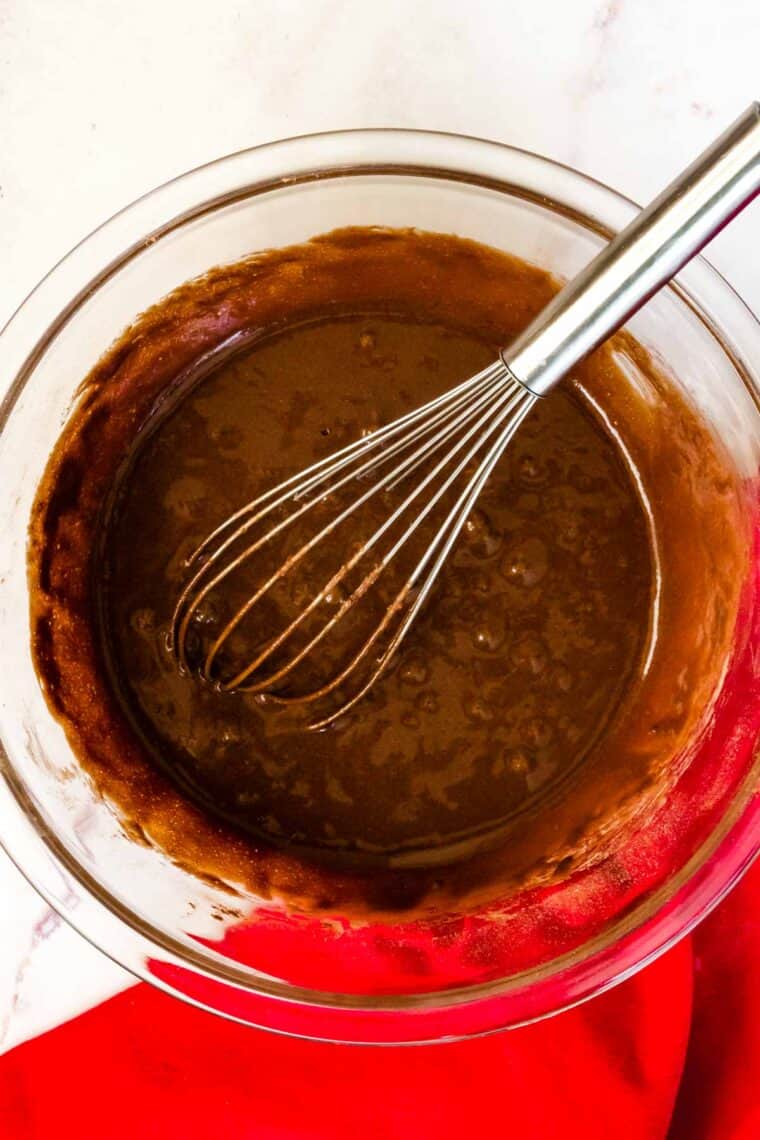 gluten free chocolate donut batter in a bowl with a whisk