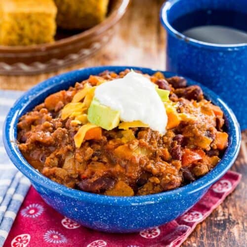 a bowl of beef chili with pineapple topped with cheese and sour cream