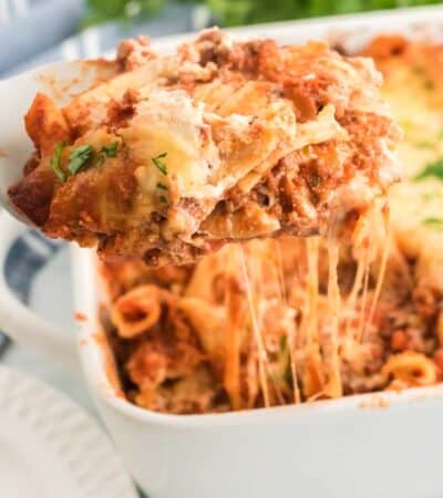 A slice of gluten free baked ziti is lifted from a casserole dish.