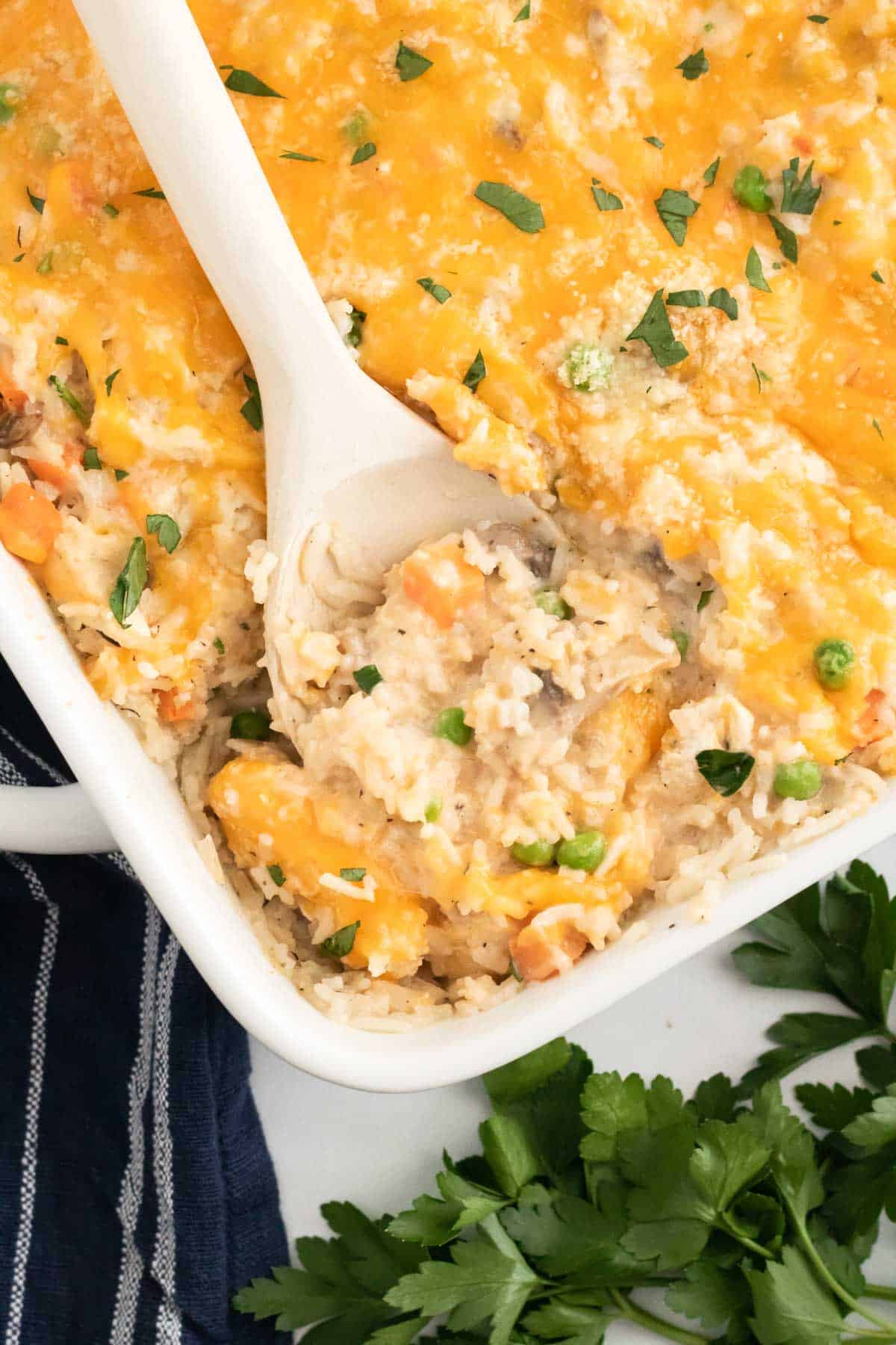 Chicken and rice is spooned out of a casserole dish.