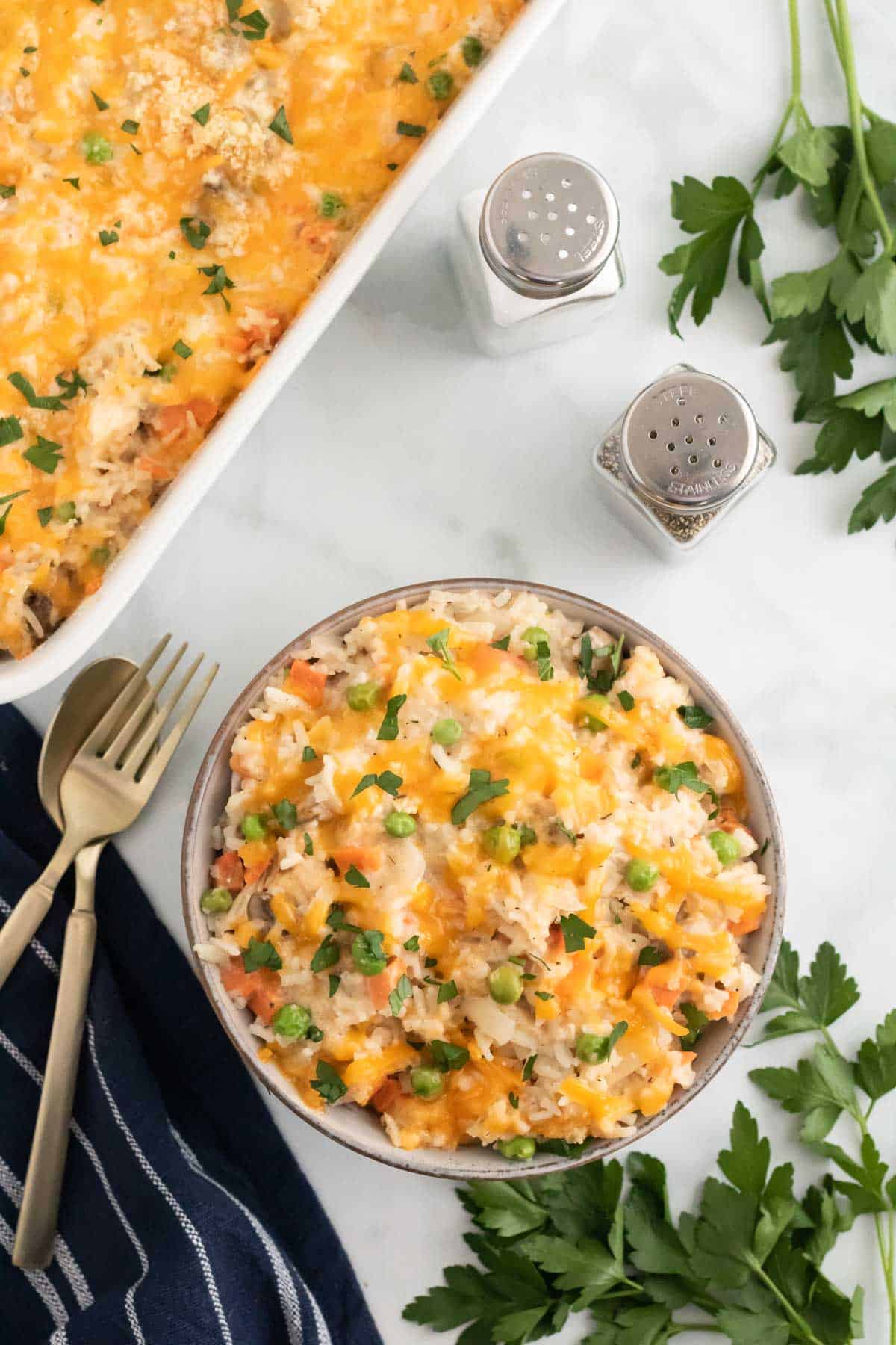 Chicken and rice casserole served in a bowl next to a casserole dish.