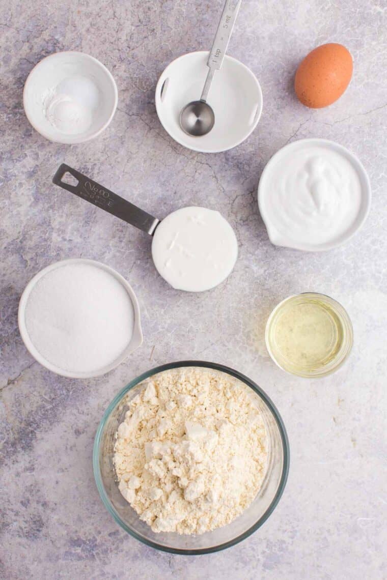 bowls of gluten free flour, sugar, oil, coconut milk, and other ingredients to make coconut cupcakes.