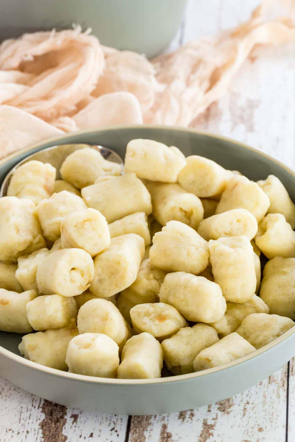 A serving dish full of cooked gluten-free gnocchi.