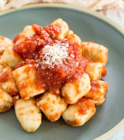 Gluten-free gnocchi served with tomato sauce and parmesan on a plate.