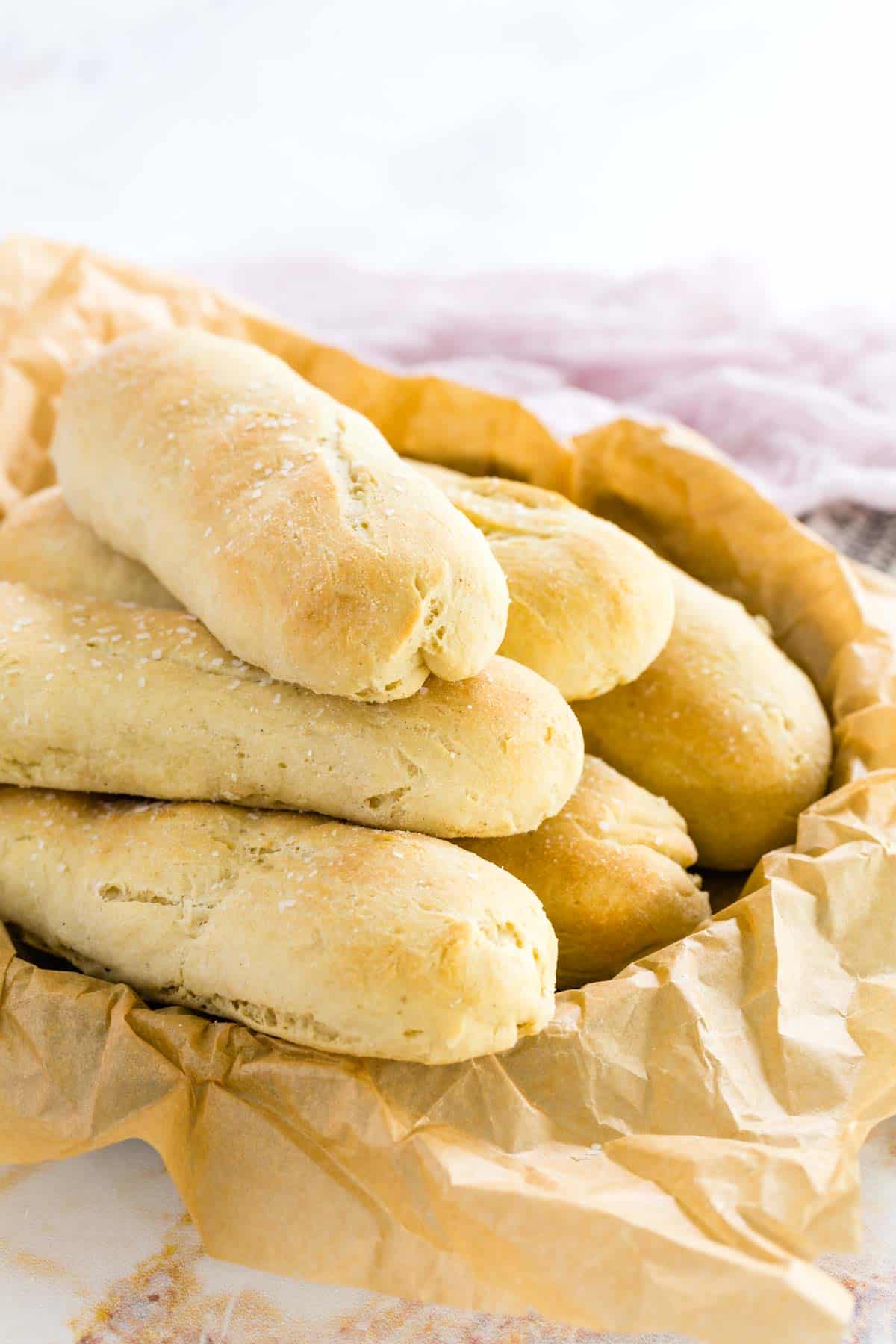 A bread basket filled with gluten free breadsticks.