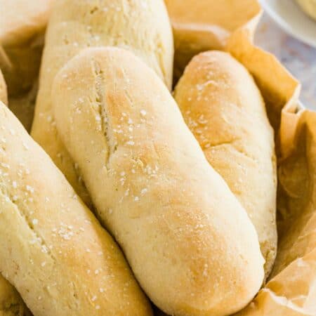 A bread basket filled with golden baked, gluten free breadsticks.