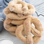 A stack of soft pretzels with one more leaning against the stack.