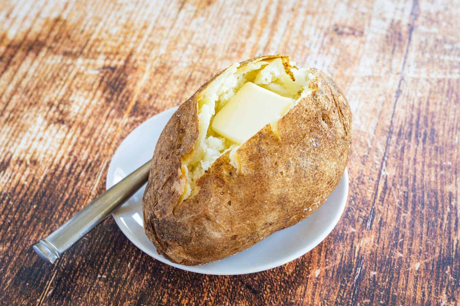 a baked potato on a plate with a fork