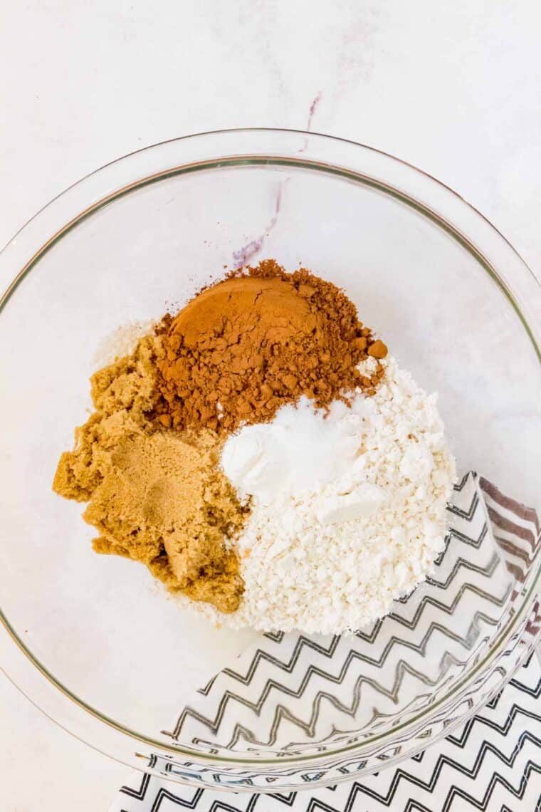 Dry ingredients for chocolate donuts are added to a mixing bowl.