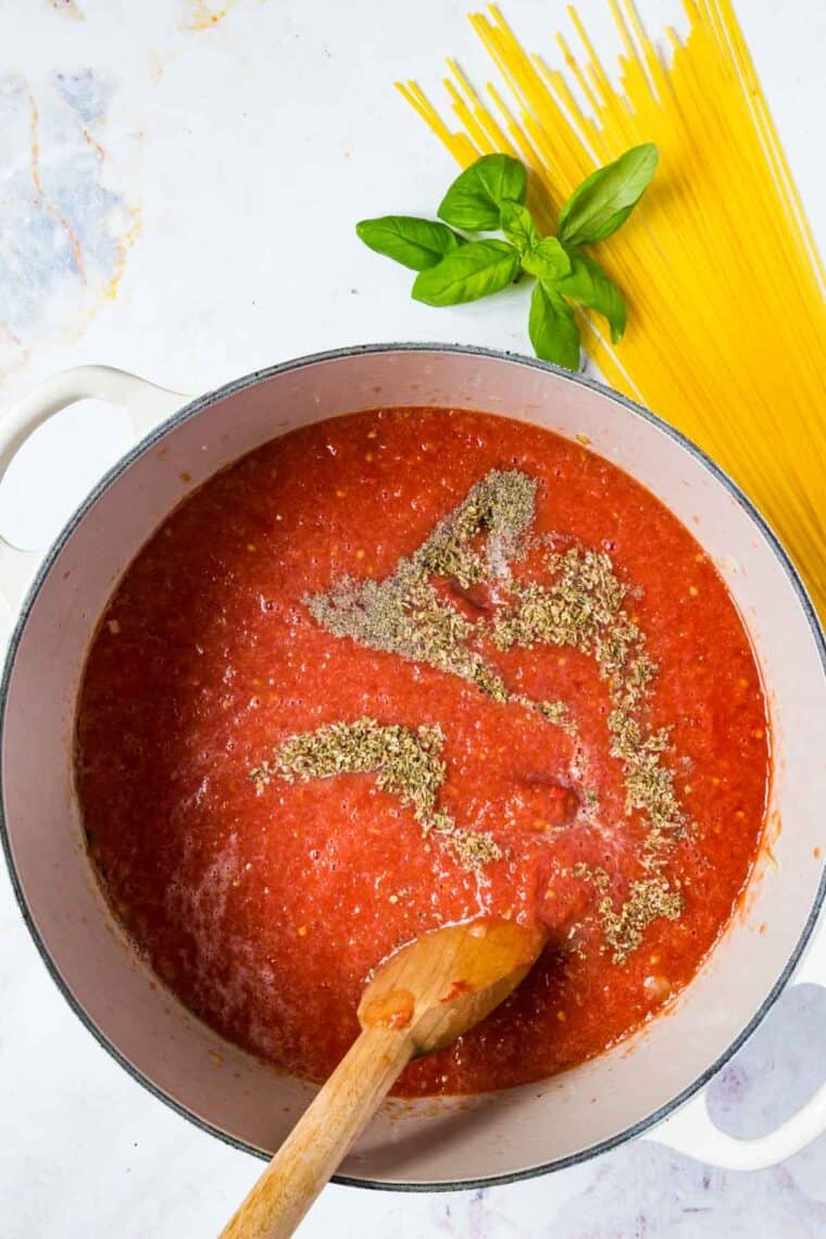 Seasonings are stirred into the tomato base for marinara sauce.