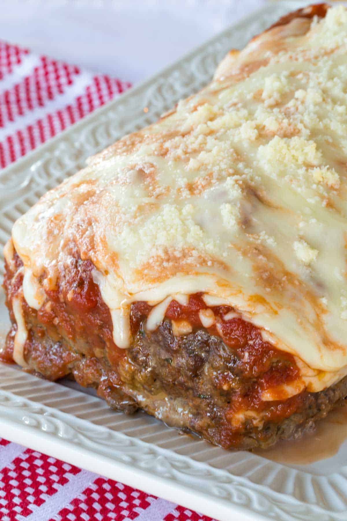 A fully baked mozzarella stuffed meatloaf on top of a fancy serving platter