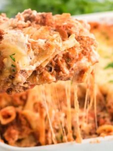 A slice of gluten free baked ziti is lifted from a casserole dish.