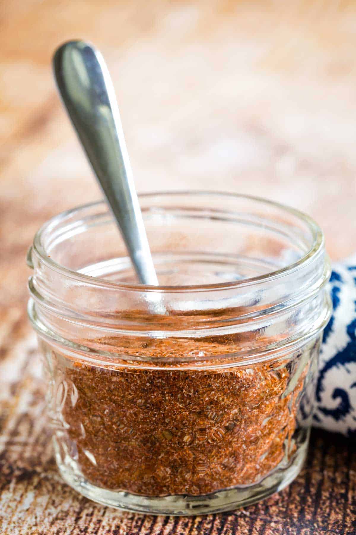 Blackening spice in a jar with a spoon.