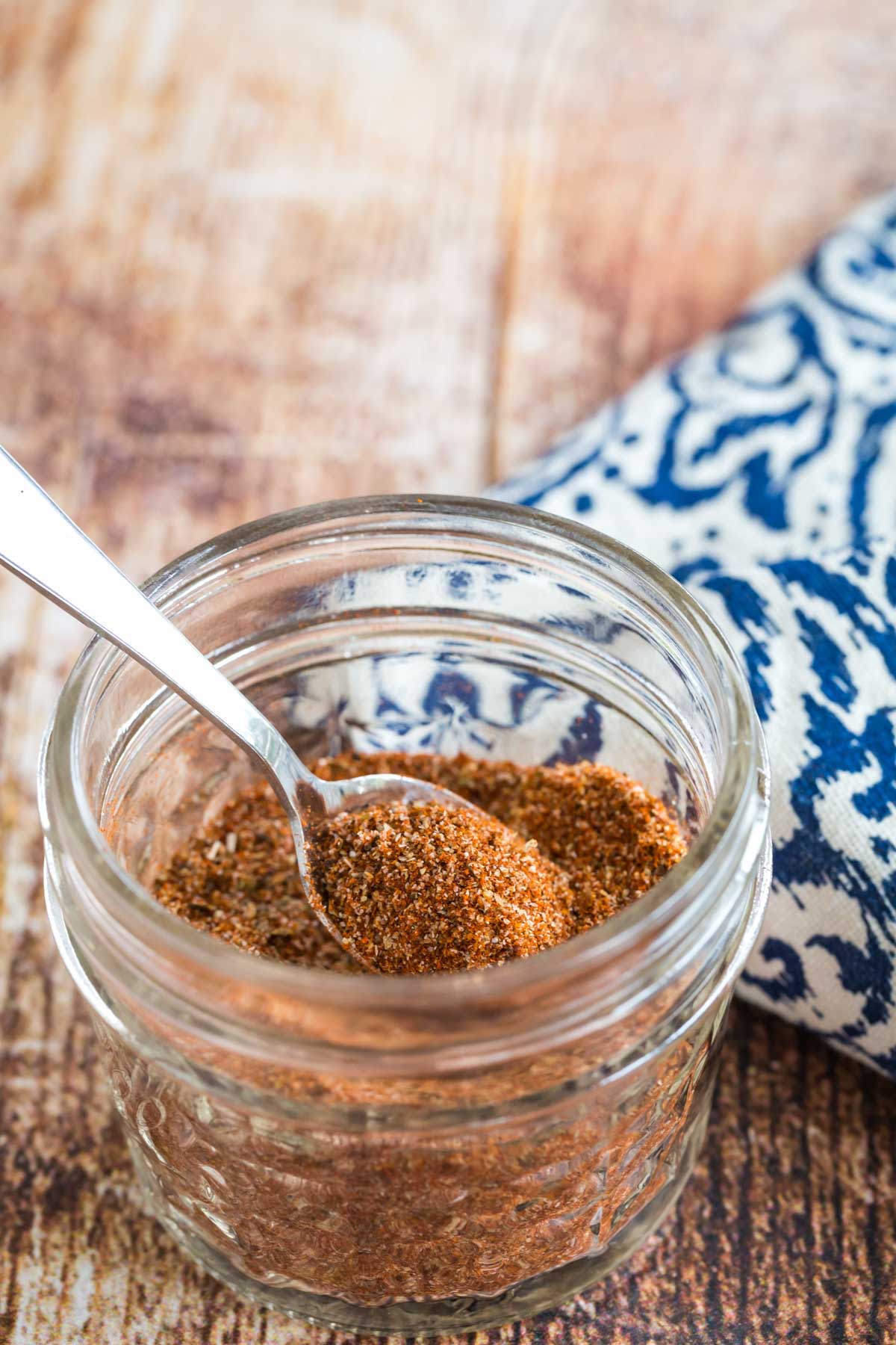 Blackening spice in a jar with a spoon.