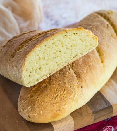 Gluten free French baguettes on a wooden cutting board.
