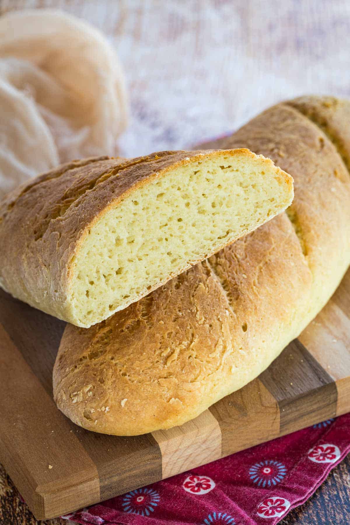 Gluten free French baguettes on a wooden cutting board.