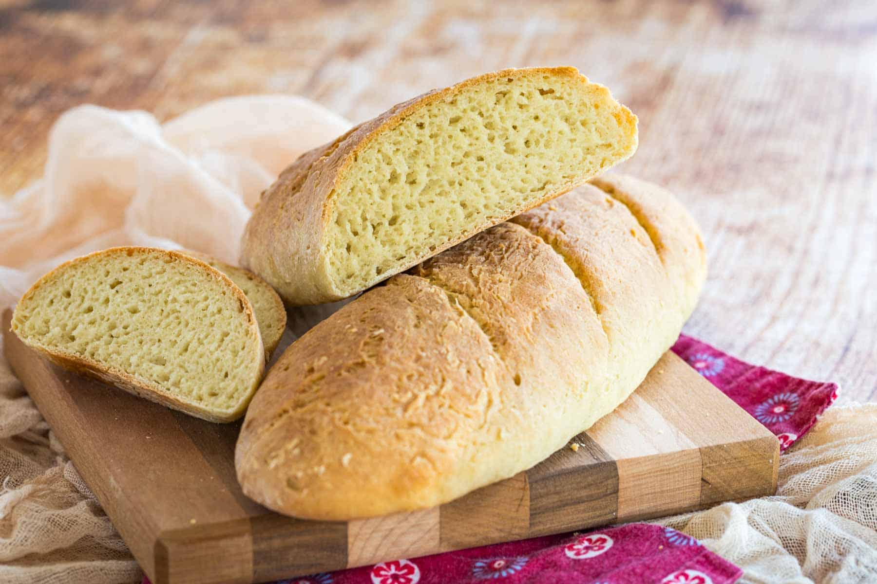 Gluten free French baguettes on a wooden cutting board.