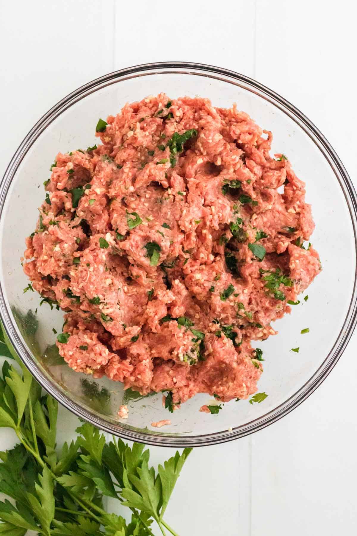 The meatloaf "dough" inside of a large glass mixing bowl