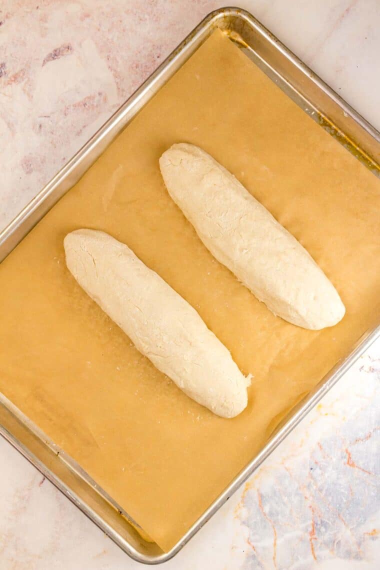 Two loaves of bread dough on a baking sheet.