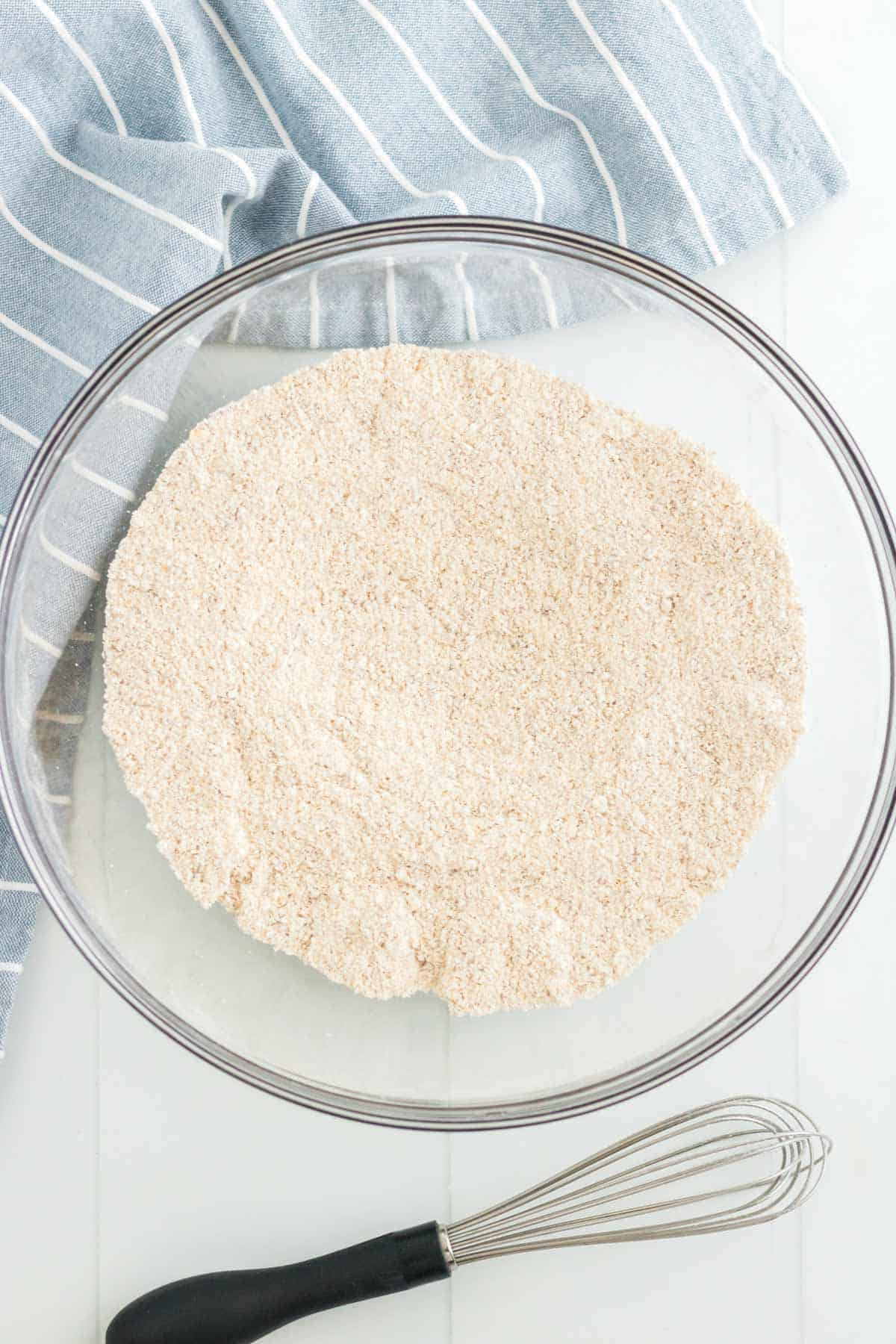 The combined dry ingredients in a glass mixing bowl on a kitchen countertop