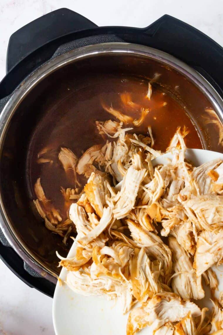 Shredded BBQ chicken is added back into the sauce in the Instant Pot.