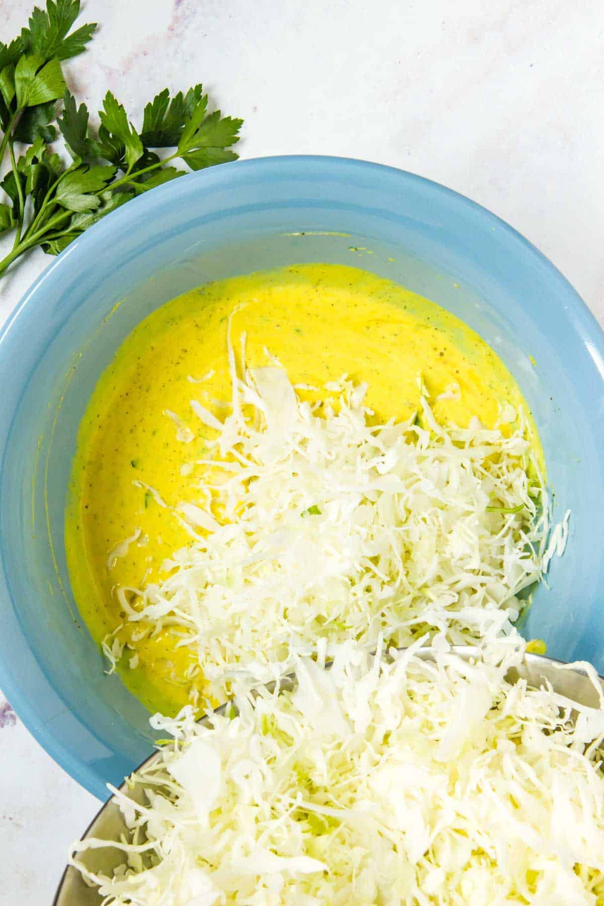 Coleslaw mix is added into the mustard dressing.