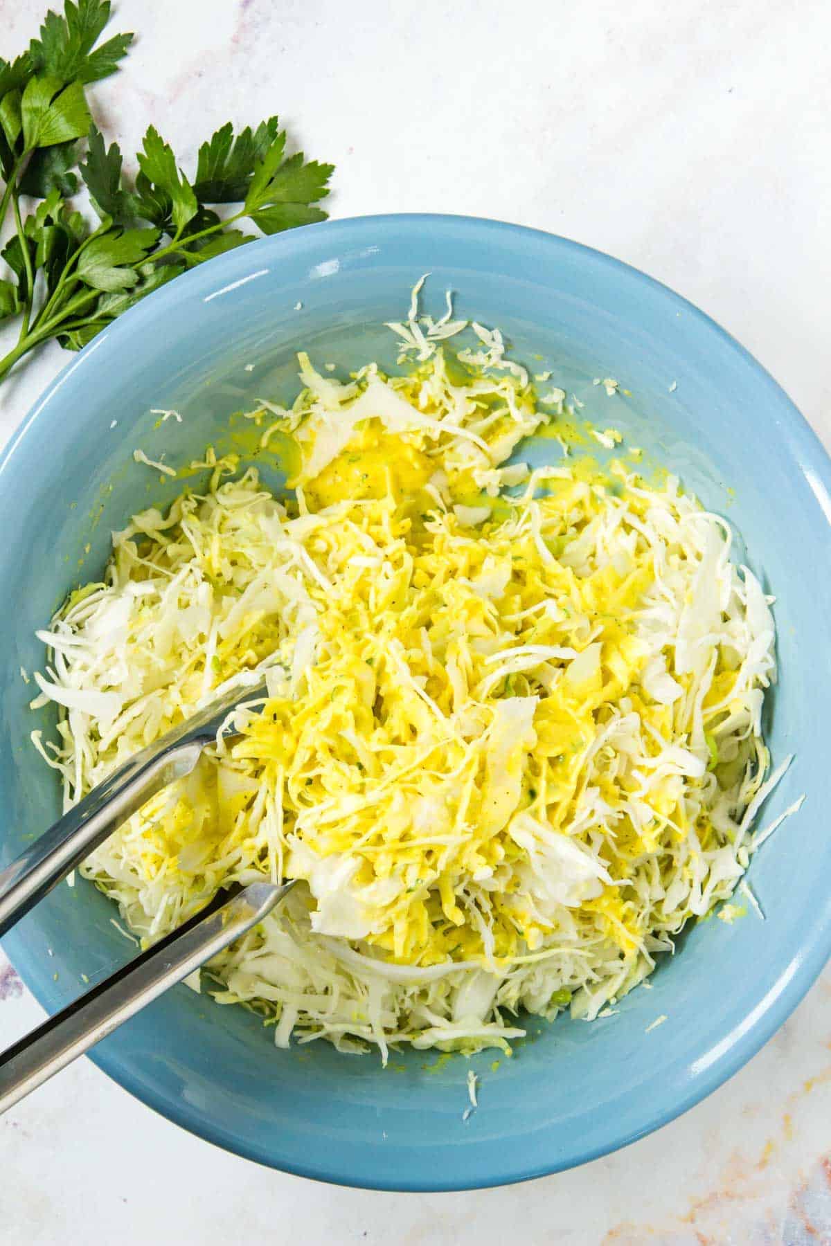 Coleslaw mixed is tossed in a creamy yellow mustard dressing.