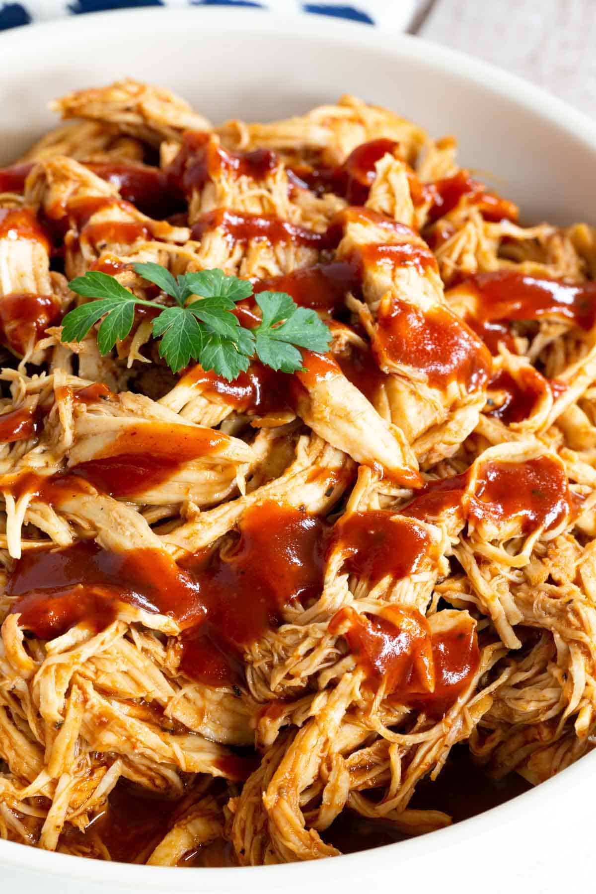 A bowl full of saucy BBQ pulled chicken.