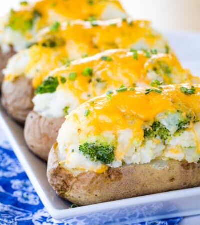 Four Broccoli Cheese Twice Baked Potatoes on a rectangular serving dish.