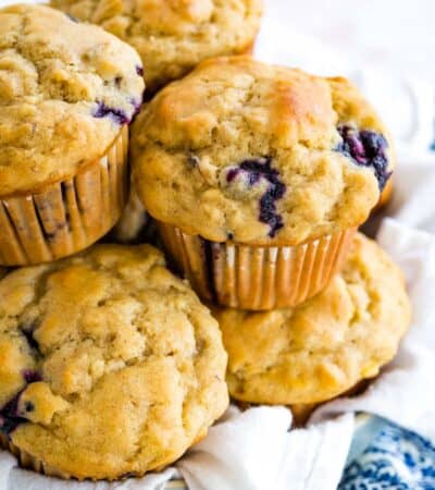 A bunch of gluten-free muffins in a basket lined with a cloth napkin