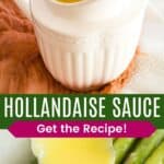 Hollandaise sauce dripping off a spoon into a white gravy pitcher and bring spooned over asparagus.