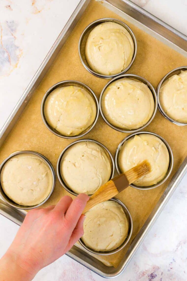 Hamburger buns are brushed with melted butter.