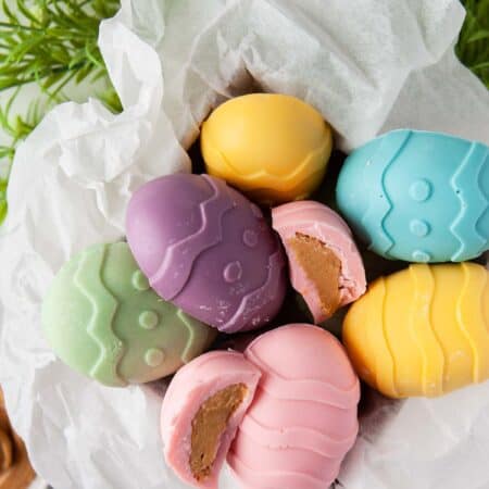 Pastel-colored peanut butter eggs in a parchment-lined box.