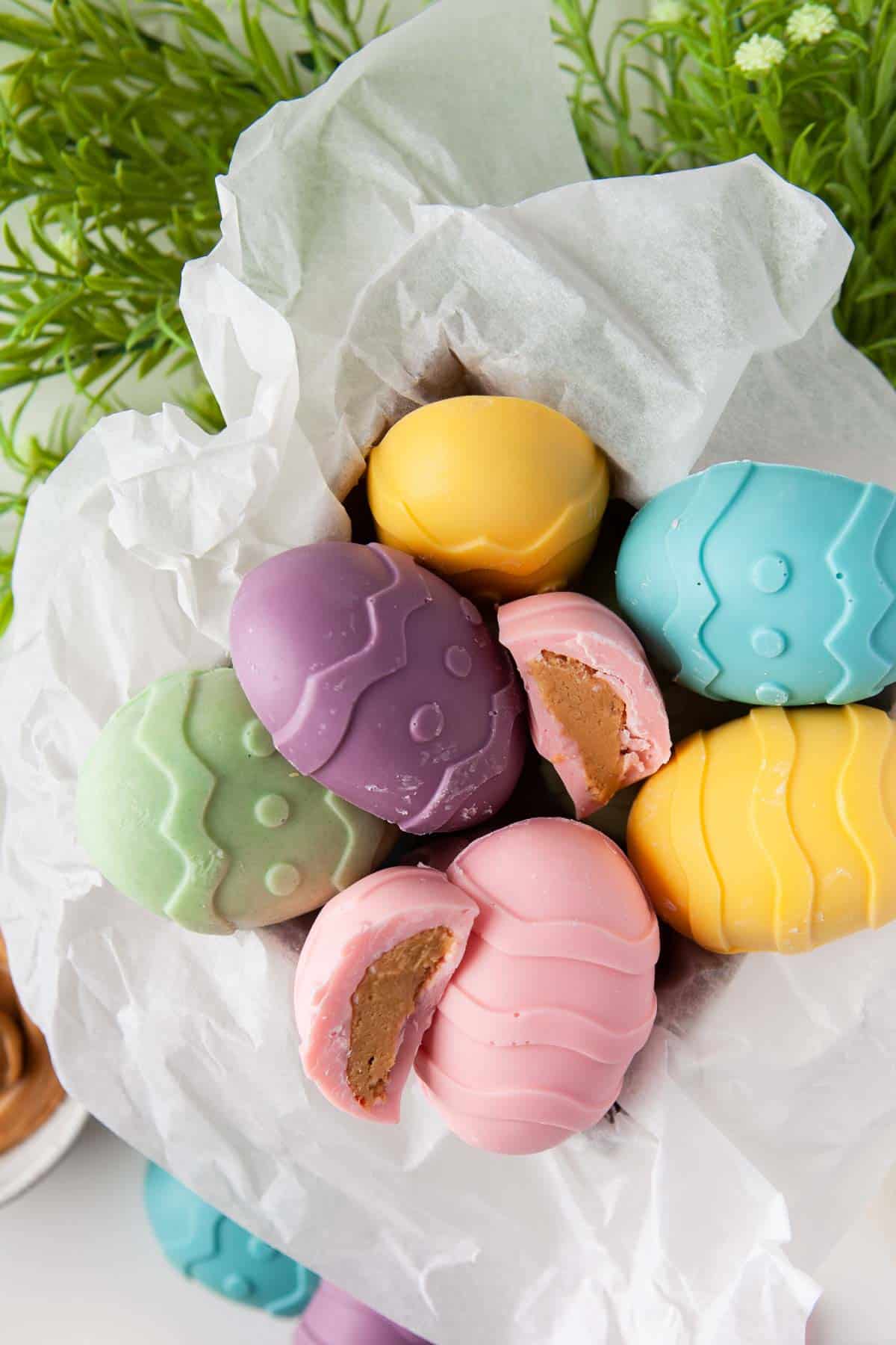 Pastel-colored peanut butter eggs in a parchment-lined box.