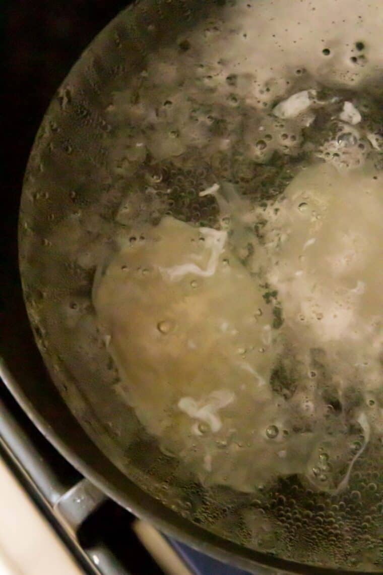 Eggs are poached in a pan of boiling water.