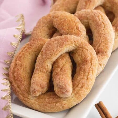 Soft pretzels with cinnamon sugar lined up on a rectangular dish.