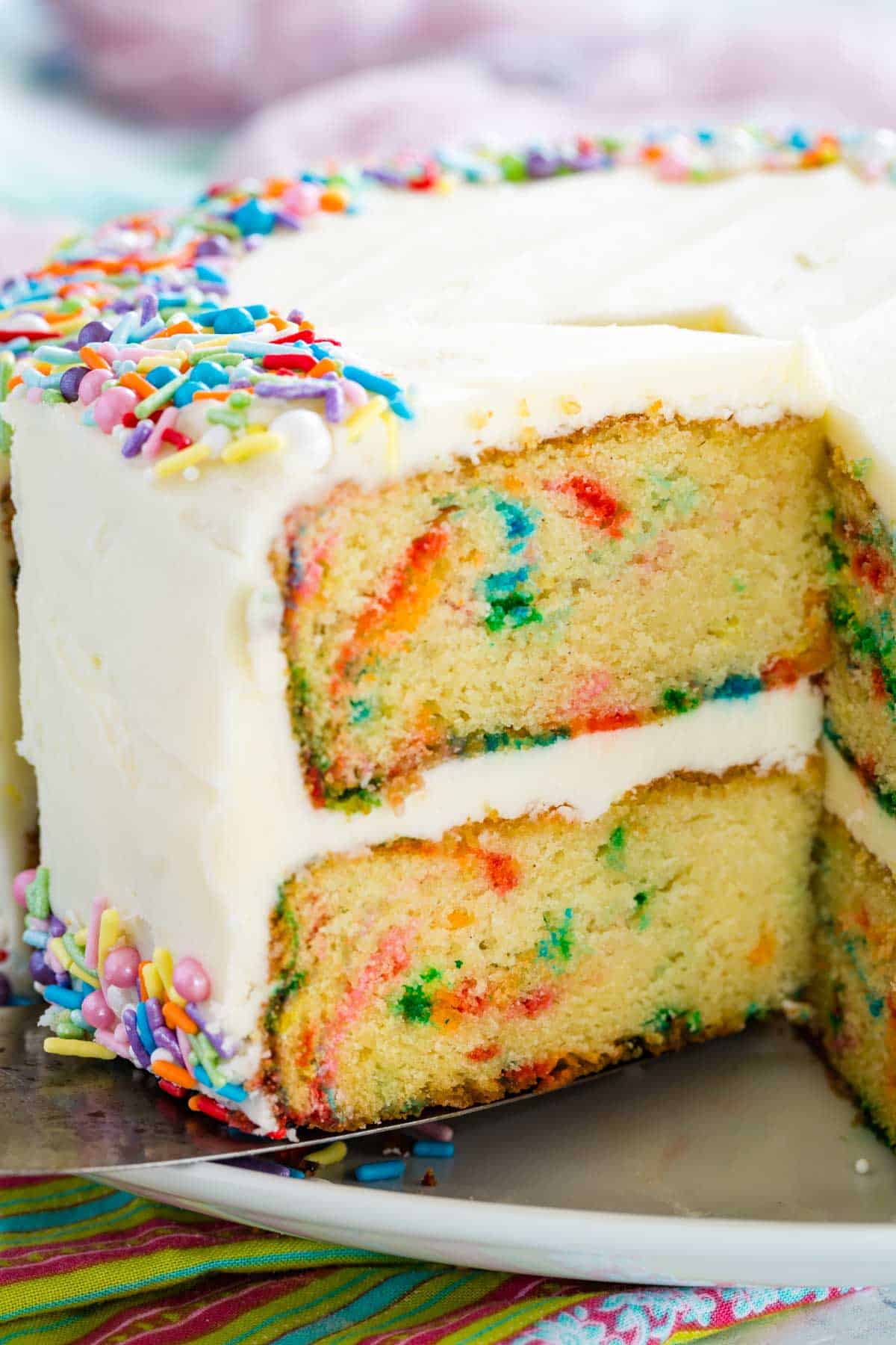 Funfetti cake with a slice missing, showing the colorful layers.