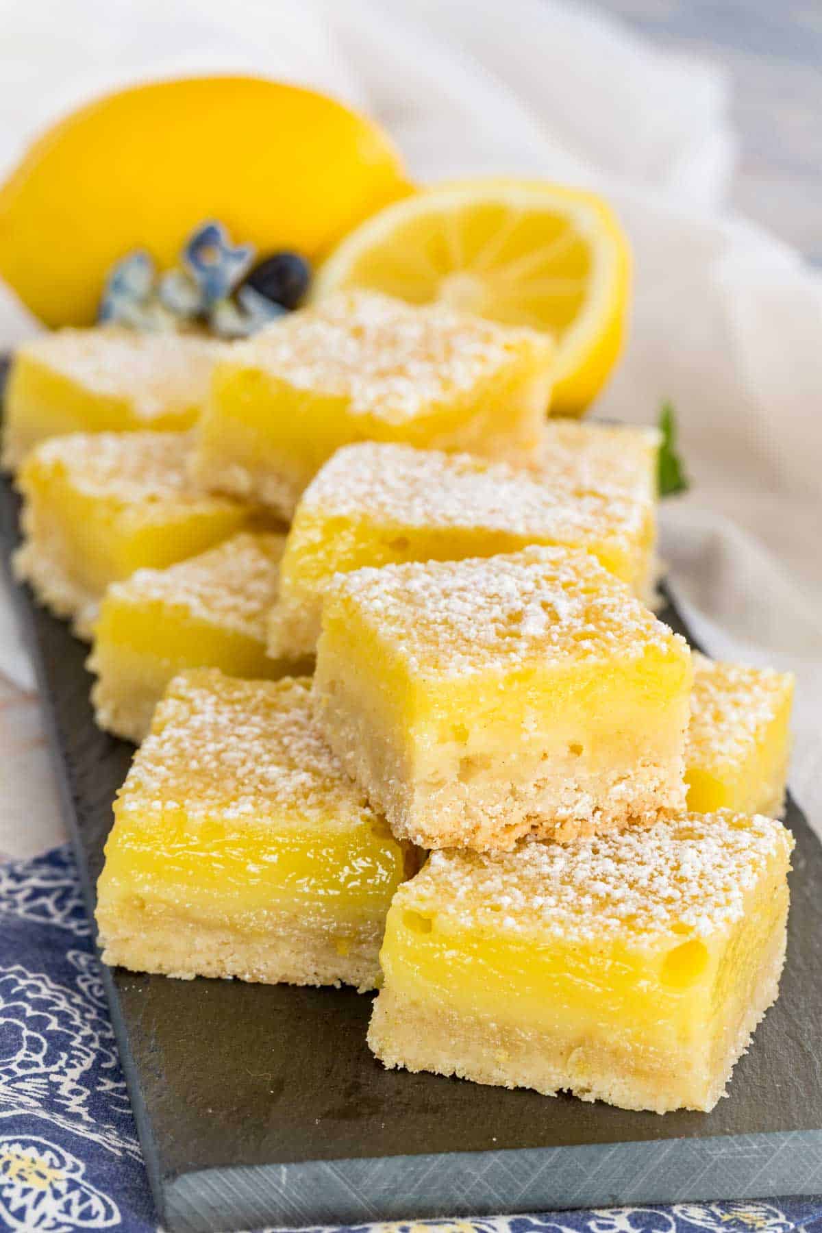 A stack of gluten free lemon bars on a rectangular platter.