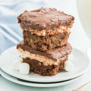 Two Rocky Road Brownies stacked on top of each other on a small white plate.