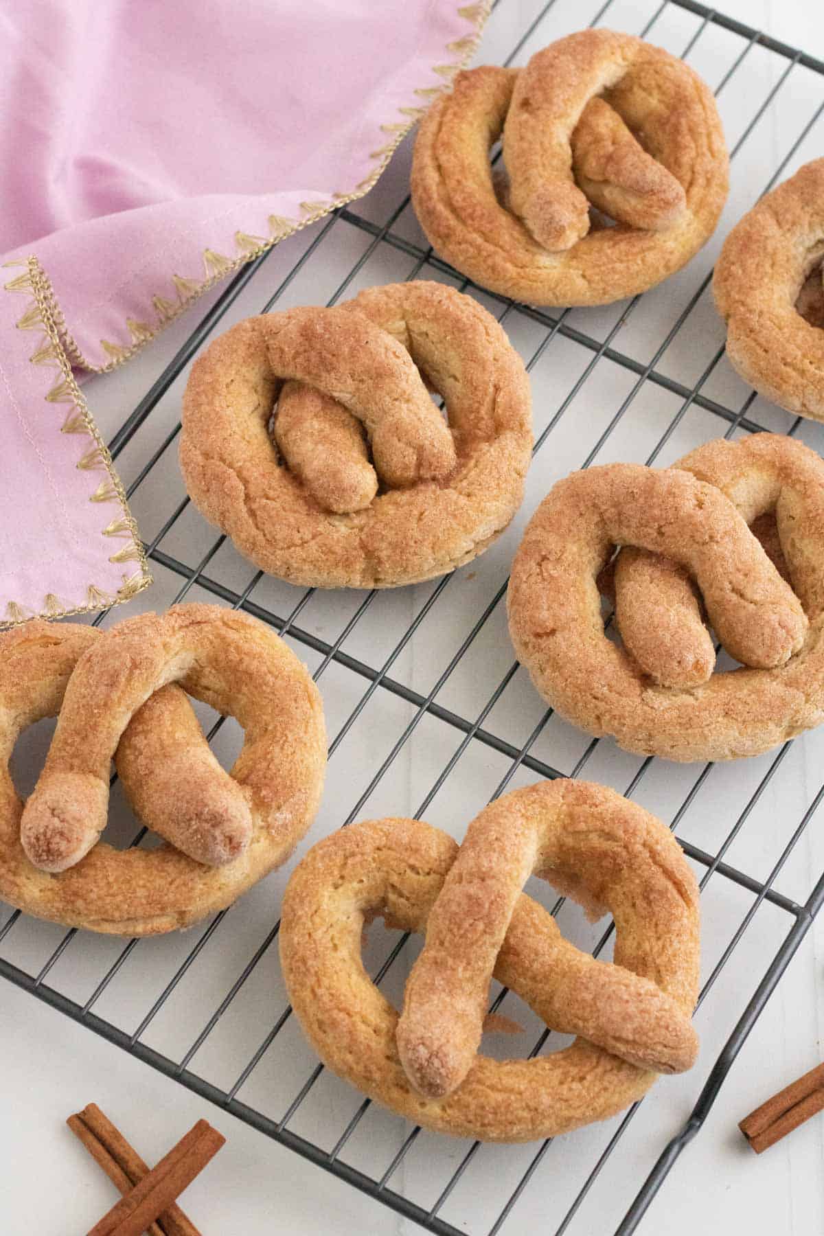 Six cinnamon sugar-coated pretzels on a cooling rack.