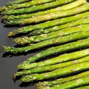 Speard of oven-roasted asparagus on a sheet pan.