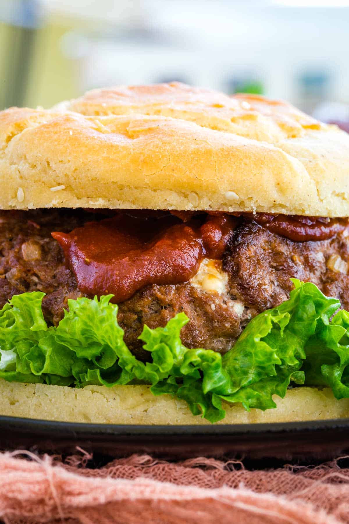 Closeup of a cooked cheese stuffed burger.